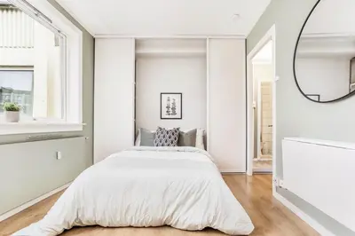 a bedroom with a bed and a mirror at Charming studio apartment in Bergen