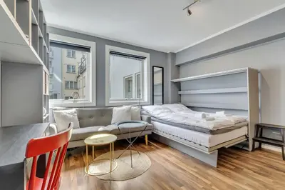 a bedroom with a bed and a couch and windows at Cozy Studio Retreat in Bergen