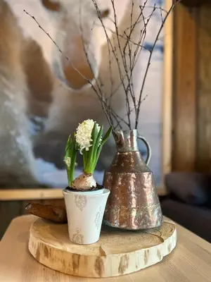 two vases sitting on a wooden table with flowers at Eventyrtunet in idyllic Tuddal in Hjartdal