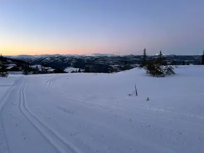 a snow covered slope with tracks in the snow at Eventyrtunet in idyllic Tuddal in Hjartdal