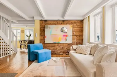 a living room with a couch and a blue chair at Dinbnb Homes I Bergen's #1 BNB I Jacuzzi & Fireplace & Balcony in Bergen