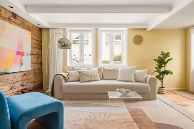 a living room with a couch and a window at Dinbnb Homes I Bergen's #1 BNB I Jacuzzi & Fireplace & Balcony in Bergen