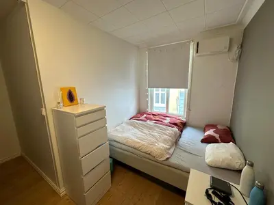 a small bedroom with a bed and a window at Sjarmerende bolig like ved togstasjonen in Bergen