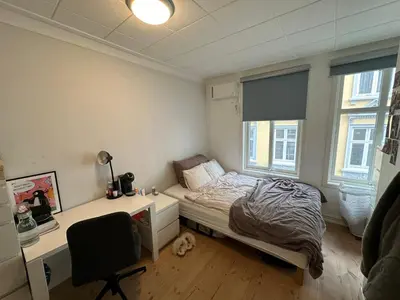 a bedroom with a bed and a desk and a chair at Sjarmerende bolig like ved togstasjonen in Bergen