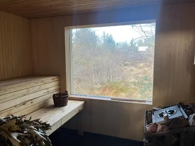 a window in a wooden room with a bench and a window at Feriehus nær sjøen på Kvenvær in Hitra