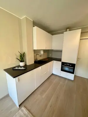 a kitchen with white cabinets and a black counter top at Modern apartment ONLY 5 minutes from City Centre in Bergen
