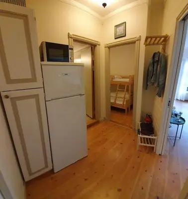 a kitchen with a white refrigerator and a wooden floor at Fin leilighet i Geilo sentrum - kort vei til alt in Geilo