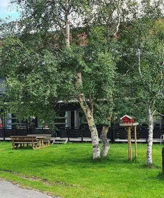 a park with a bench and a bird house in the grass at Fin leilighet i Geilo sentrum - kort vei til alt in Geilo