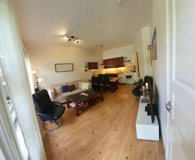 a living room with a couch and a table and chairs at Fin leilighet i Geilo sentrum - kort vei til alt in Geilo