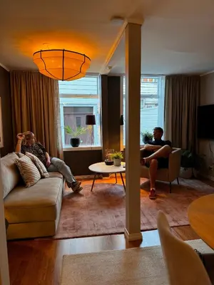 two men are sitting in a living room at The DreamHouse - inner City Center - Old Town in Bergen