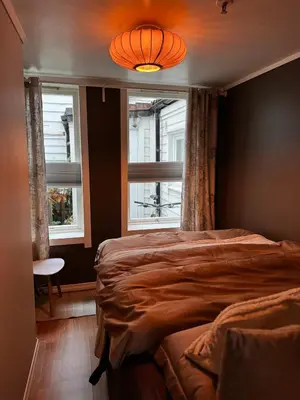 a bedroom with a large bed and two windows at The DreamHouse - inner City Center - Old Town in Bergen