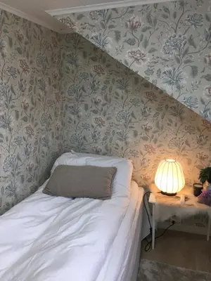 a bedroom with a bed and a table with a lamp at Villa Skoglund in Stranda