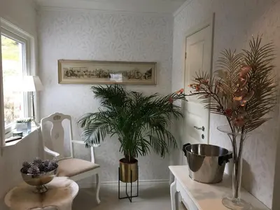 a bathroom with a table with a plant and a chair at Villa Skoglund in Stranda