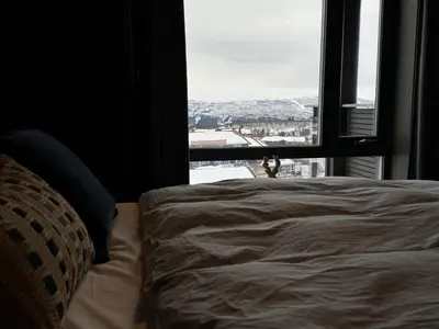 a bedroom with a bed and a large window at Riddertunet Beitostølen in Beitostøl