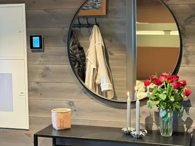 a table with a vase of flowers and a mirror at Riddertunet Beitostølen in Beitostøl