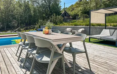 a table and chairs on a wooden deck next to a pool at 3 Bedroom Stunning Home In Vikebygd in Vikebygd