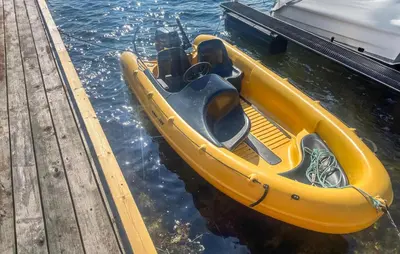 a yellow boat in the water next to a dock at Stunning Home In Sveio With Kitchen in Sveio