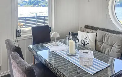 a dining room table with a candle and a couch at Stunning Home In Sveio With Kitchen in Sveio