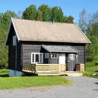 a small house with a porch and a deck at Camp Sjusjøen in Mesnali
