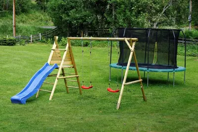 a playground with two swings and a slide at Camp Sjusjøen in Mesnali