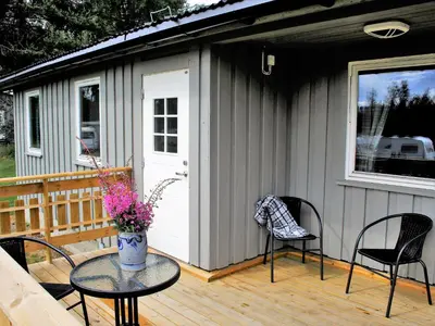 a house with a table and chairs on a deck at Camp Sjusjøen in Mesnali