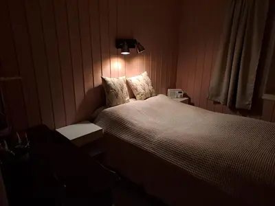 a bedroom with a bed and a light on the wall at Bay View Island Room - Svanøy in Svanøy