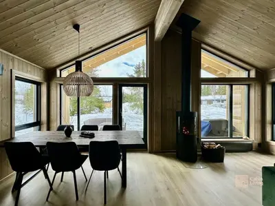 a dining room with a large wooden table and chairs at New cabin at Skeikampen, perfect for families! in Svingvoll