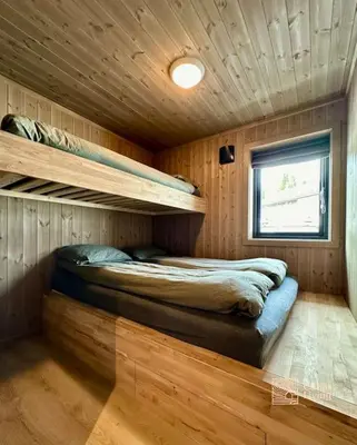 a bedroom with a bed in a wooden cabin at New cabin at Skeikampen, perfect for families! in Svingvoll