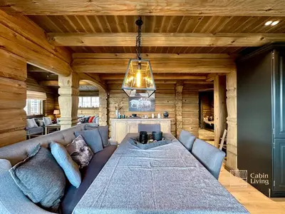 a living room with a large couch and a chandelier at New log cabin with sauna, waxing shed & bench at Sjusjøen in Ringsaker