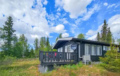 a cabin in the woods with a chair in front of it at Beautiful Home In Gol With Kitchen in Gol