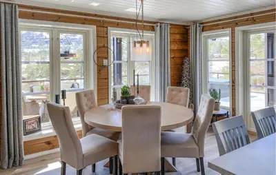 a dining room with a table and chairs and windows at Awesome Home In Stryn in Stryn