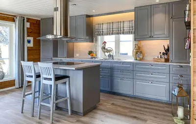 a kitchen with blue cabinets and a island with stools at Awesome Home In Stryn in Stryn
