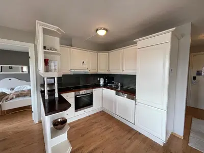 a kitchen with white cabinets and a bed at Relaxing Retreat With Two Terraces in Beitostøl