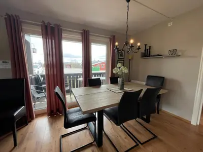 a dining room with a table and chairs and a large window at Relaxing Retreat With Two Terraces in Beitostøl
