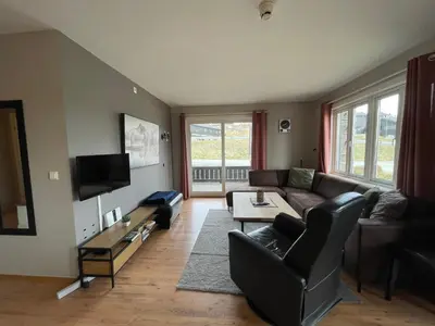 a living room with a couch and a tv at Relaxing Retreat With Two Terraces in Beitostøl