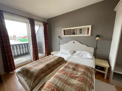 a bedroom with two beds and a large window at Relaxing Retreat With Two Terraces in Beitostøl