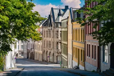 an empty street in a city with buildings at Sunny apartment in Ålesund city in Ålesund