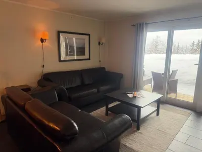 a living room with a couch and a table at Enjoy Comfort Wi-Fi, Sauna & More! in Beitostøl