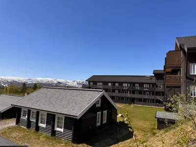 a small black house in front of a building at Enjoy Comfort Wi-Fi, Sauna & More! in Beitostøl