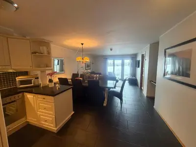 a kitchen and living room with a table and a dining room at Enjoy Comfort Wi-Fi, Sauna & More! in Beitostøl