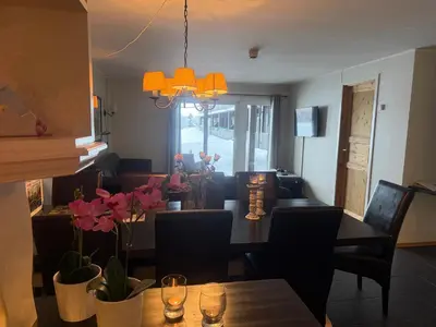a dining room with a table with flowers on it at Enjoy Comfort Wi-Fi, Sauna & More! in Beitostøl