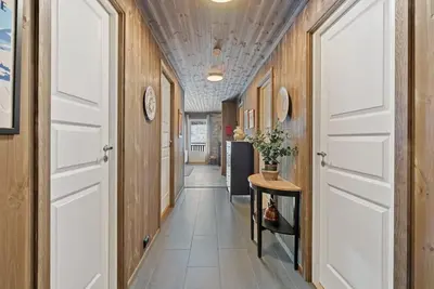 a hallway with two white doors and a table at Cozy Apartment close to Hovden alpine centre in Hovden
