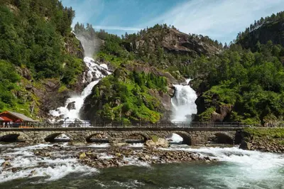 a bridge over a river with a waterfall at Odda Atmosphere in Odda
