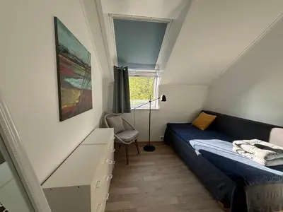 a small bedroom with a bed and a window at Stenegården in Namsos