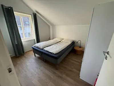 a small bedroom with a bed and a window at Stenegården in Namsos