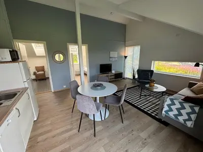 a kitchen and living room with a table and chairs at Stenegården in Namsos