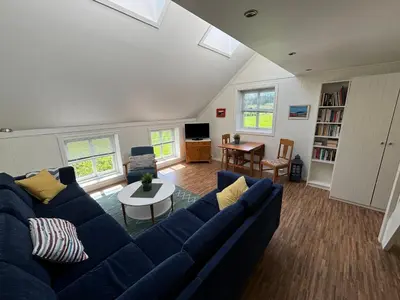 a living room with a blue couch and a table at Stenegården in Namsos