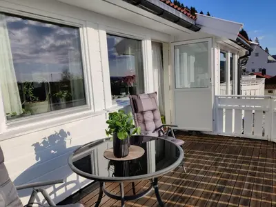a glass table and a chair on a porch at Nearby Bergen, Midtunlia 27d in Bergen