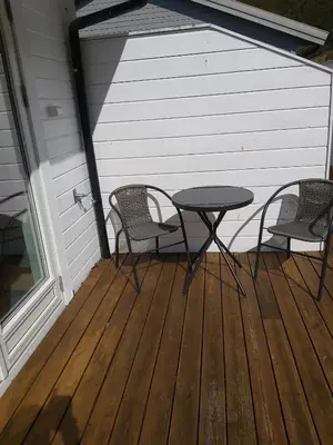 a patio with two chairs and a table on a deck at Nearby Bergen, Midtunlia 27d in Bergen