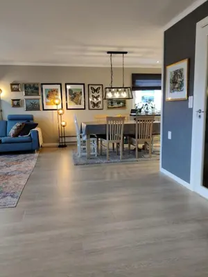 a dining room and living room with a table and chairs at Nearby Bergen, Midtunlia 27d in Bergen